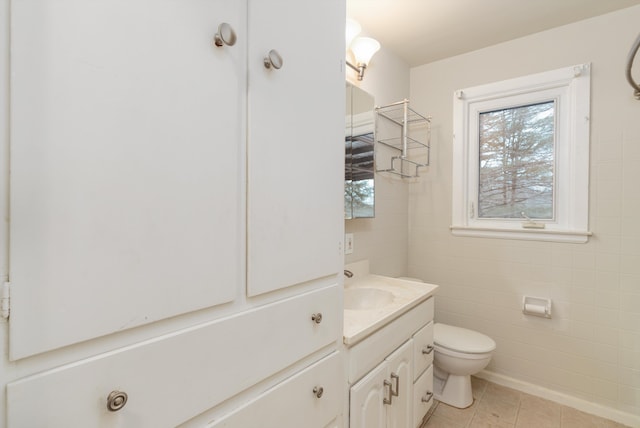 bathroom featuring tile patterned flooring, vanity, tile walls, and toilet