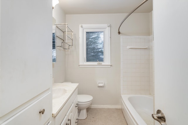 full bathroom featuring vanity, tile patterned floors, tiled shower / bath combo, toilet, and tile walls