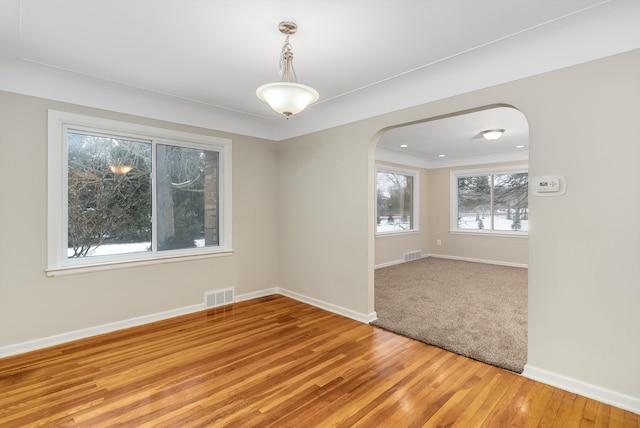 spare room with plenty of natural light and hardwood / wood-style flooring