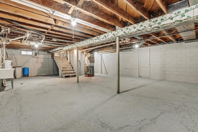 basement with electric water heater, heating unit, and electric panel