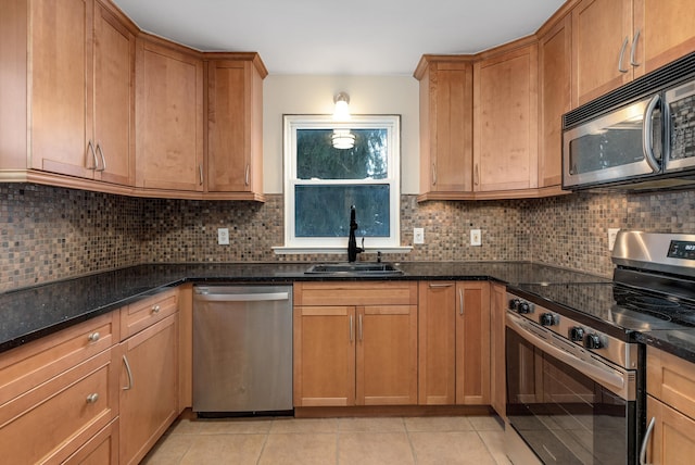 kitchen with light tile patterned flooring, sink, stainless steel appliances, and tasteful backsplash