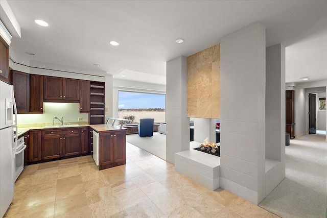 kitchen with oven, sink, light colored carpet, and a center island