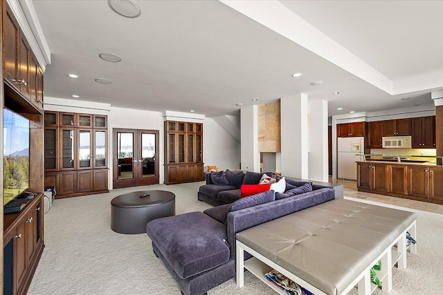 living room featuring plenty of natural light, light colored carpet, and french doors