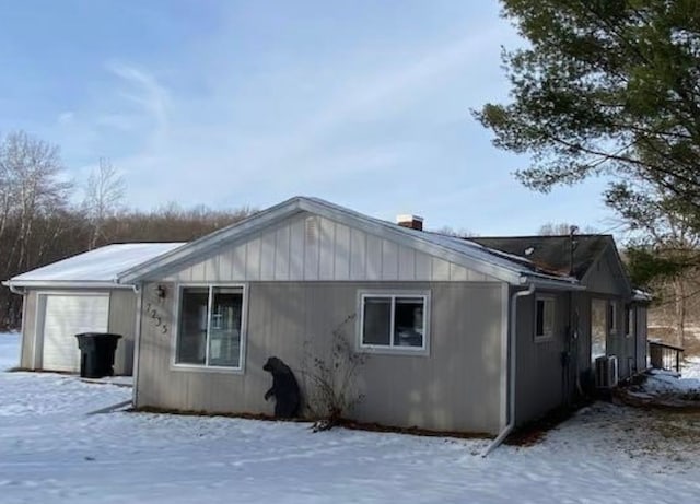 view of snowy exterior featuring a garage