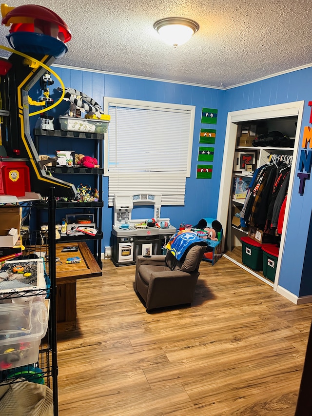 rec room featuring wood-type flooring and a textured ceiling