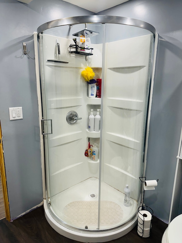 bathroom featuring hardwood / wood-style floors, toilet, and an enclosed shower