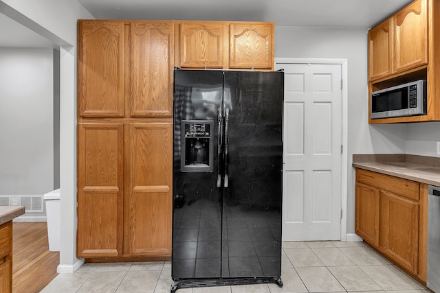 kitchen featuring light tile patterned flooring and stainless steel appliances