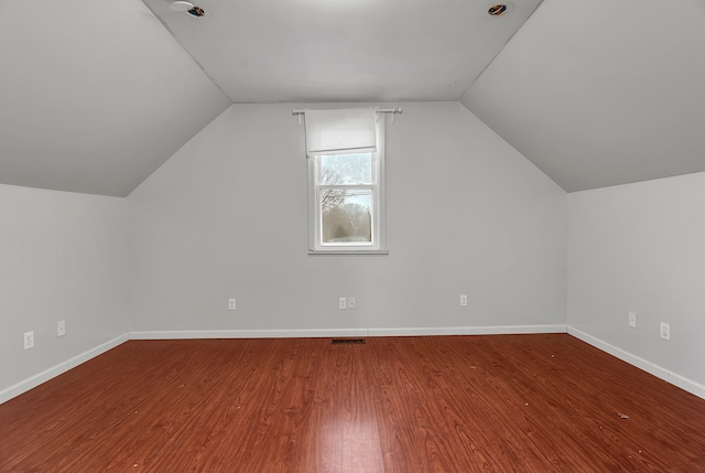 additional living space featuring hardwood / wood-style floors and lofted ceiling