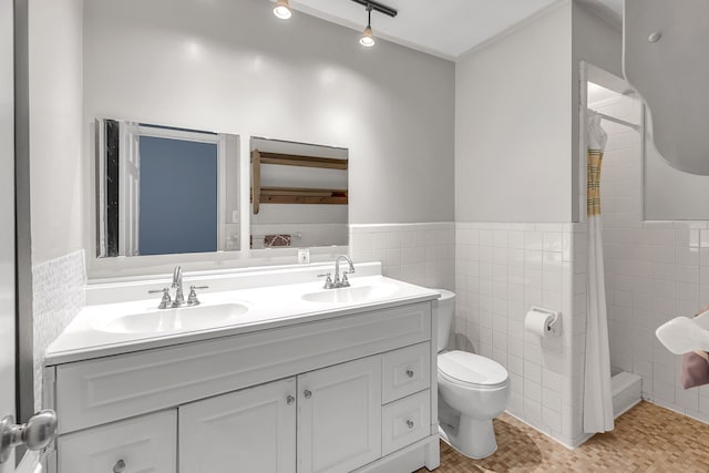 bathroom featuring toilet, vanity, tile patterned floors, and tile walls