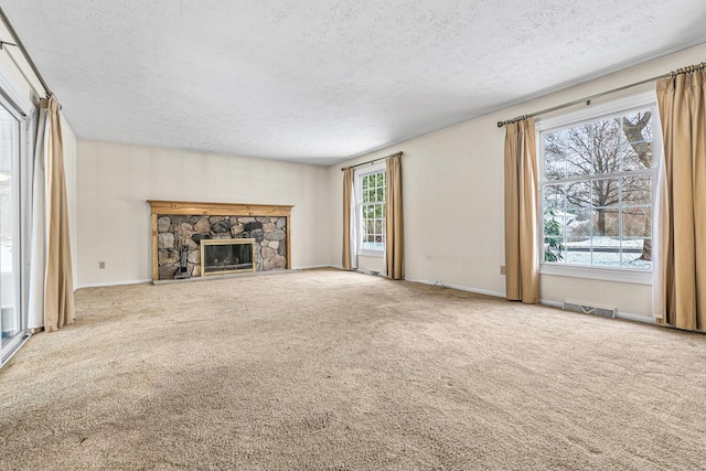 unfurnished living room with a fireplace, carpet, and a textured ceiling