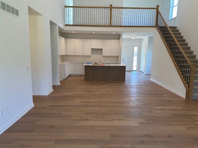 kitchen with white cabinets, dark hardwood / wood-style floors, a kitchen island, and a healthy amount of sunlight