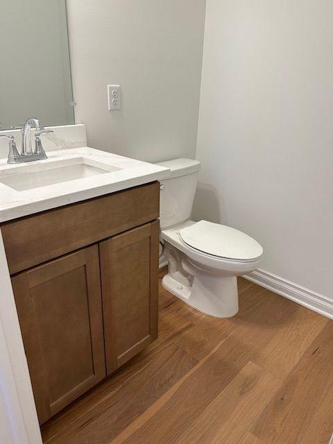 bathroom featuring wood-type flooring, vanity, and toilet