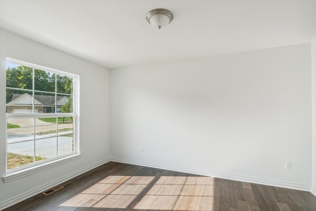 unfurnished room with dark hardwood / wood-style flooring and a healthy amount of sunlight