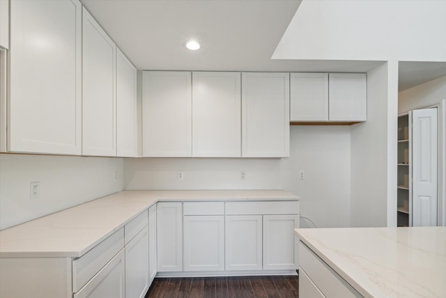 kitchen with light stone counters and white cabinetry