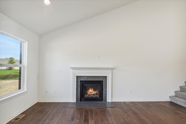 unfurnished living room with dark hardwood / wood-style flooring, plenty of natural light, and lofted ceiling