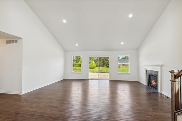 unfurnished living room featuring a high end fireplace, high vaulted ceiling, and dark wood-type flooring