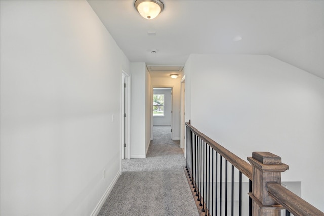 hallway featuring light colored carpet and lofted ceiling