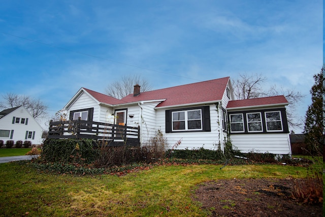 view of front of house with a wooden deck and a front lawn