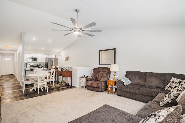 carpeted living room with ceiling fan and lofted ceiling