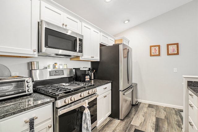 kitchen with white cabinetry, dark stone counters, and appliances with stainless steel finishes