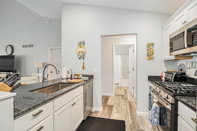 kitchen with white cabinetry, sink, appliances with stainless steel finishes, and dark stone counters