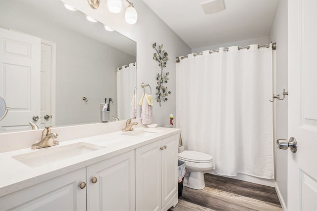 full bathroom featuring hardwood / wood-style flooring, vanity, toilet, and shower / tub combo with curtain