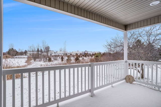 view of snow covered back of property