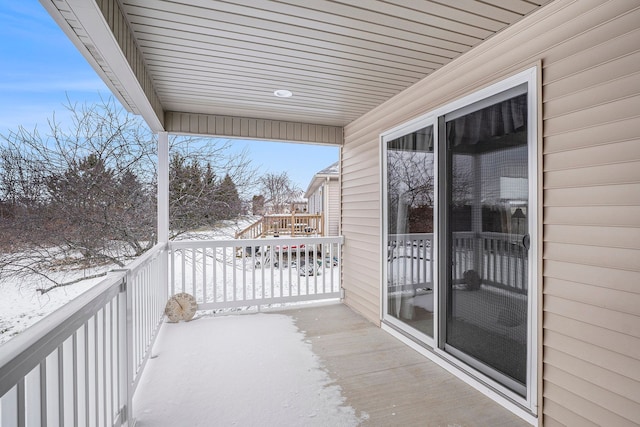 view of snow covered back of property