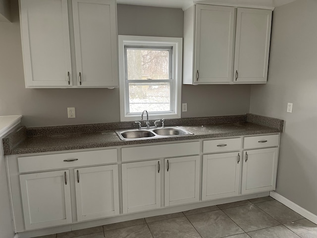 kitchen with sink, white cabinets, and light tile patterned flooring