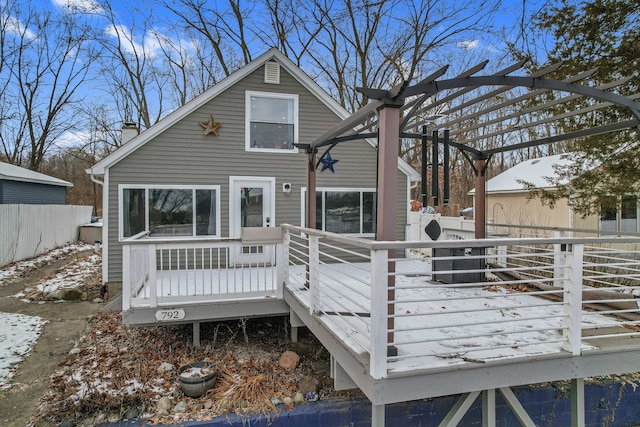 snow covered property featuring a pergola and a wooden deck