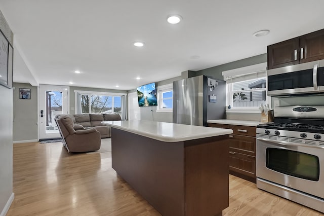 kitchen featuring dark brown cabinets, a kitchen island, light hardwood / wood-style floors, and stainless steel appliances