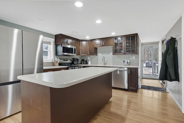 kitchen with a kitchen island, sink, dark brown cabinetry, and stainless steel appliances