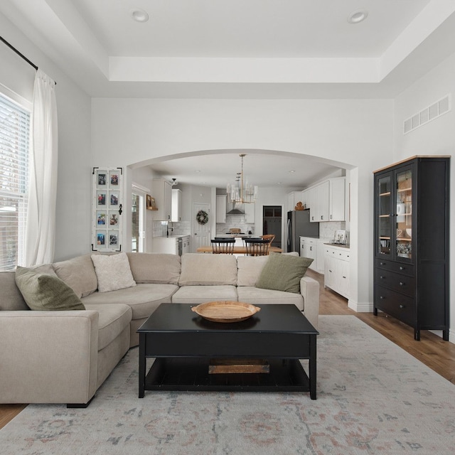 living room featuring a raised ceiling and hardwood / wood-style flooring