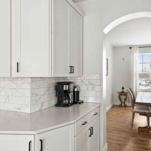 bar with white cabinets, tasteful backsplash, and hardwood / wood-style floors