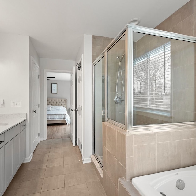 bathroom featuring tile patterned floors, independent shower and bath, and vanity