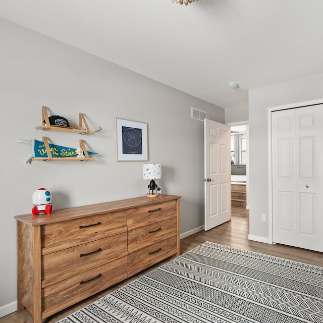 bedroom with dark hardwood / wood-style flooring and a closet