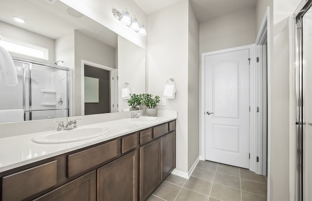 bathroom featuring tile patterned floors, a shower with shower door, and vanity