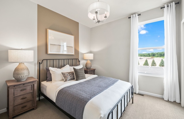 bedroom featuring light colored carpet and a chandelier