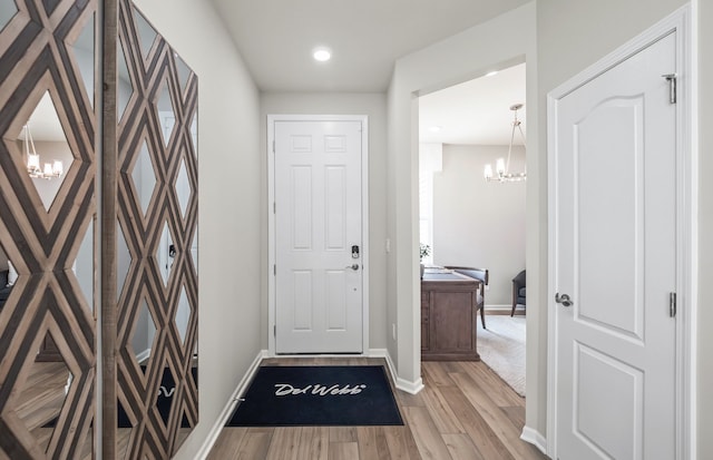 doorway featuring an inviting chandelier and light hardwood / wood-style floors