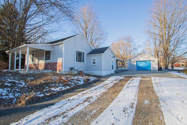 view of snow covered exterior with an outbuilding, covered porch, and a garage