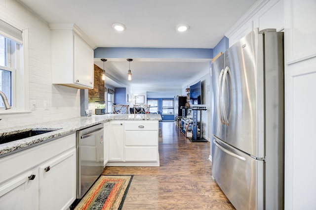 kitchen featuring kitchen peninsula, appliances with stainless steel finishes, sink, white cabinets, and dark hardwood / wood-style floors