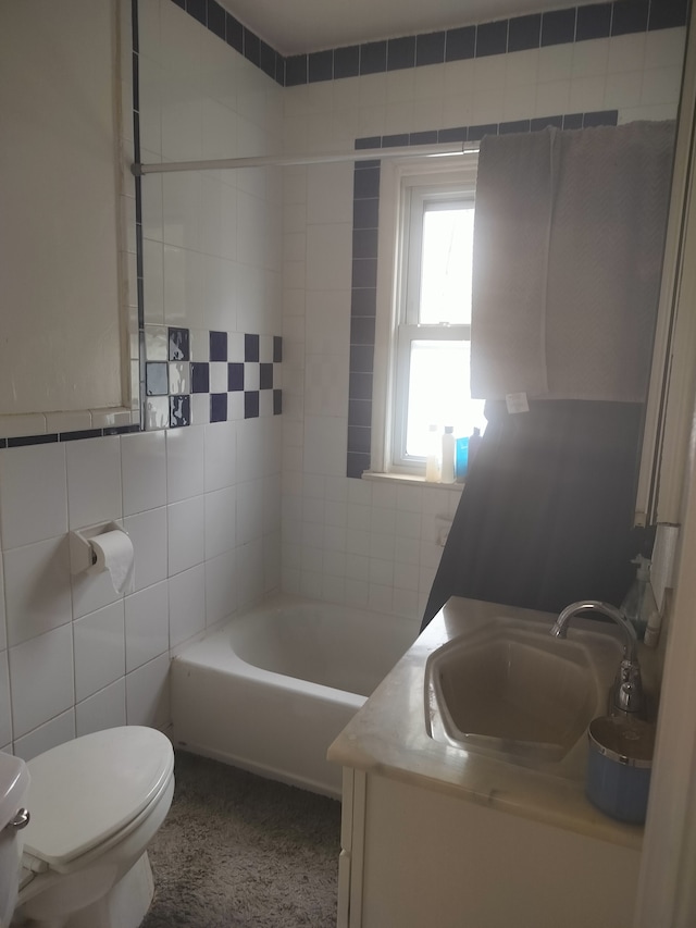 bathroom featuring vanity, toilet, and tile walls