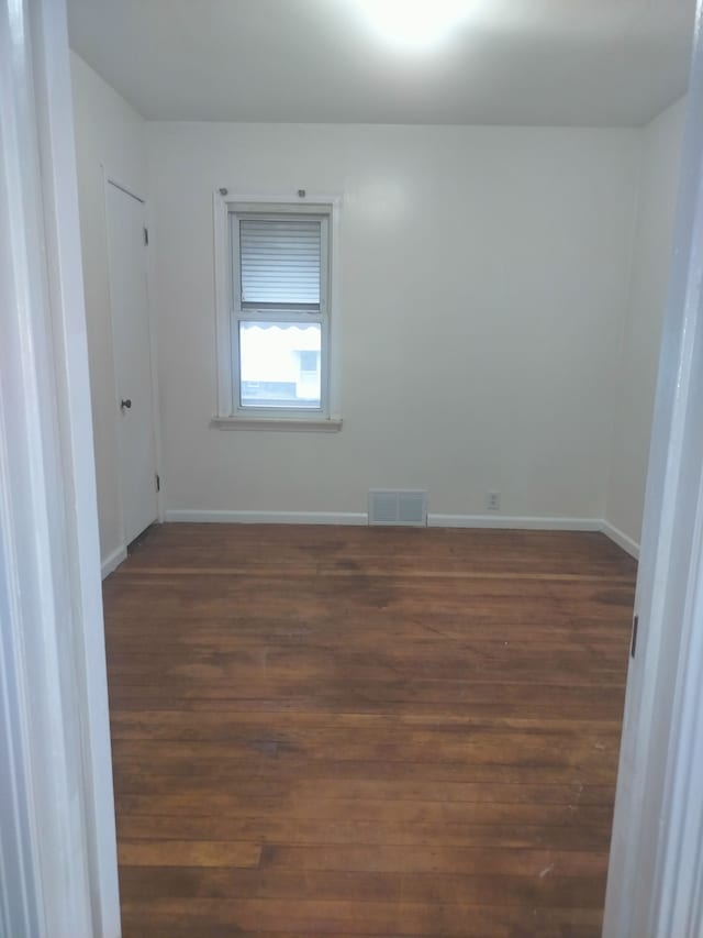 spare room with dark hardwood / wood-style floors