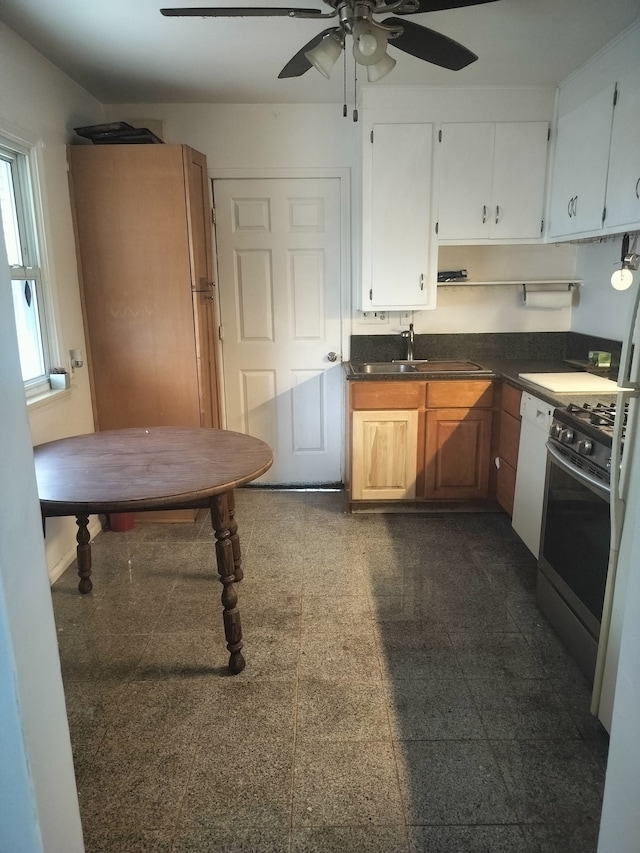 kitchen with white cabinetry, stainless steel gas stove, sink, ceiling fan, and white dishwasher