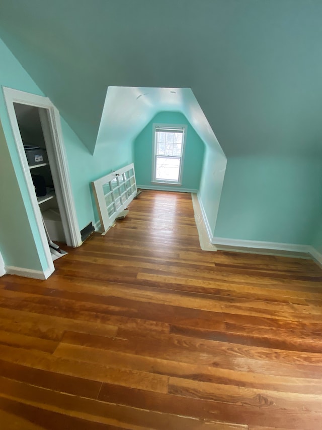 additional living space featuring vaulted ceiling and dark hardwood / wood-style floors