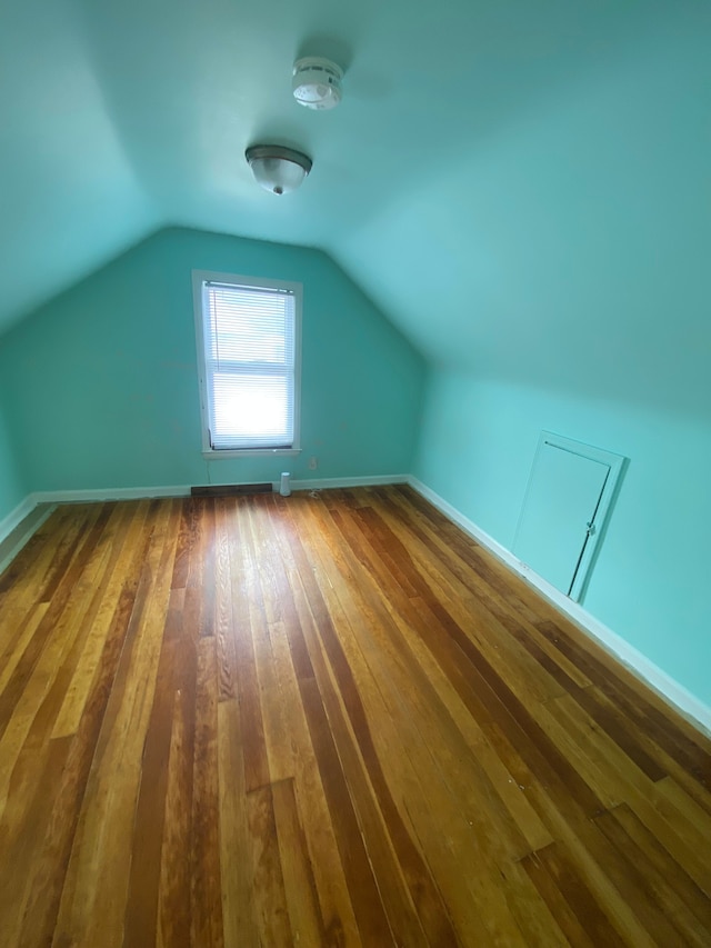 additional living space featuring hardwood / wood-style floors and lofted ceiling