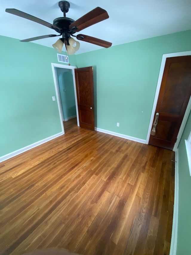 unfurnished bedroom with a closet, ceiling fan, and dark hardwood / wood-style flooring