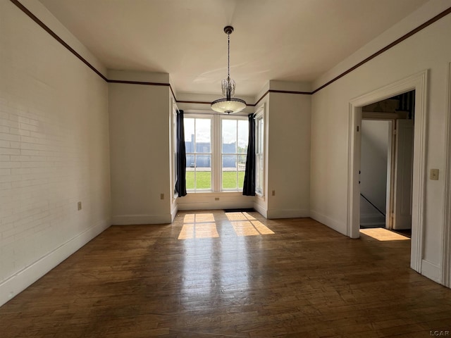 unfurnished room featuring hardwood / wood-style flooring and brick wall