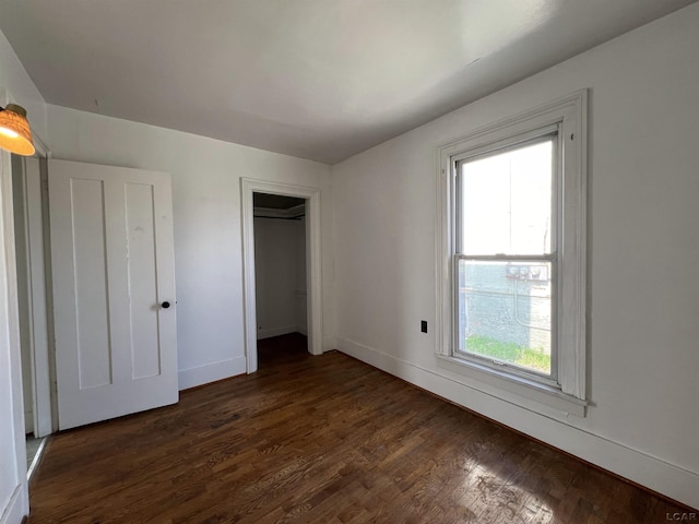 unfurnished bedroom featuring dark hardwood / wood-style flooring and multiple windows