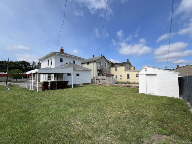 rear view of property with a shed and a yard